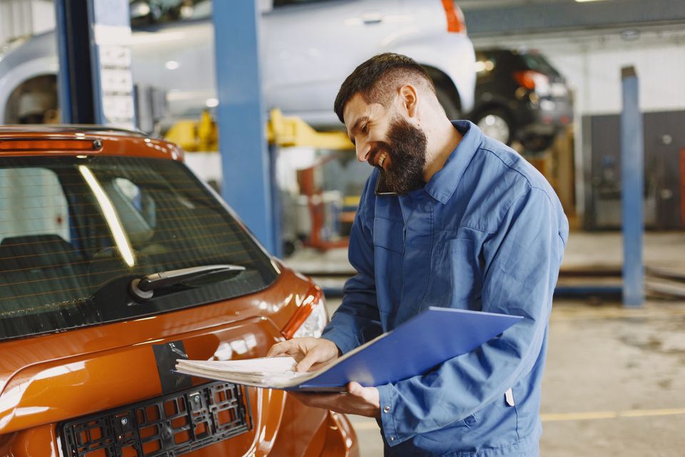 Il meccanico prepara il preventivo accanto all'auto